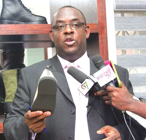 Dr Karl Laryea, Chief Executive Officer, Knights Ghana Limited, showing to the media one of his footwear products at the press conference Dr Karl Laryea, Chief Executive Officer, Knights Ghana Limited, showing to the media one of his footwear products at the press conference